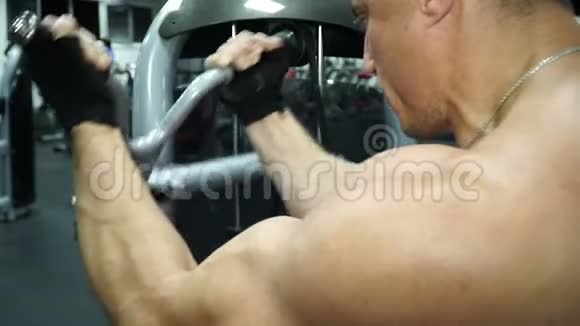 男运动员在健身房的模拟器上训练慢动作视频的预览图