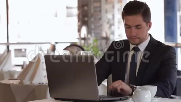 午餐时间在咖啡馆用笔记本电脑的男人视频的预览图