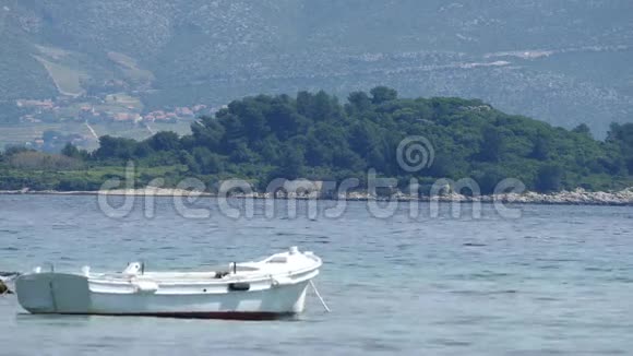 船和平静的大海一个小岛的背景兰巴达镇在科尔库拉岛视频的预览图