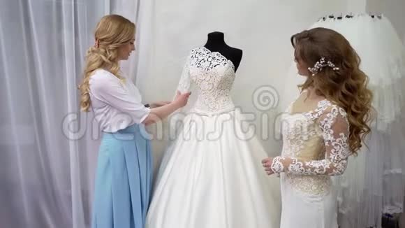 新娘在服装店买婚纱她正在挑选礼服设计师正在协助她视频的预览图