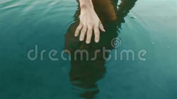 美丽的修剪过的女人的双手紧紧地握在干净的蓝色水中带着一群小鱼团结的美好时刻视频的预览图