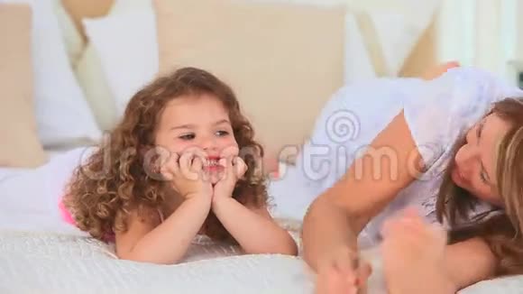 女孩和她的祖母躺在床上视频的预览图