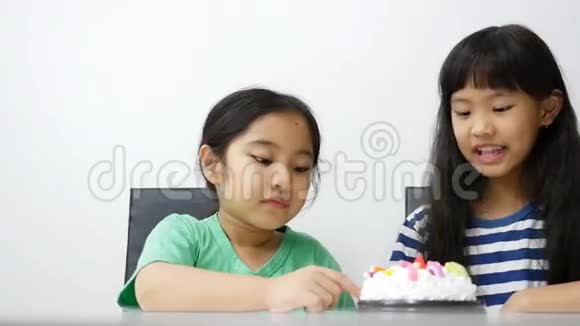 快乐的亚洲女孩享受生日蛋糕上的奶油视频的预览图