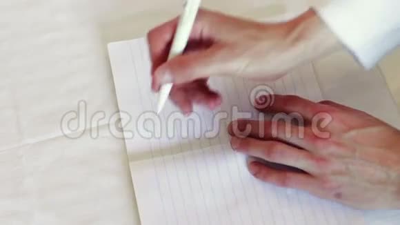 人在笔记本上写笔我爱的短语视频的预览图