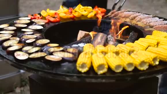 圆形烧烤架里面有明火准备夏季野餐的食物玉米茄子铃椒视频的预览图