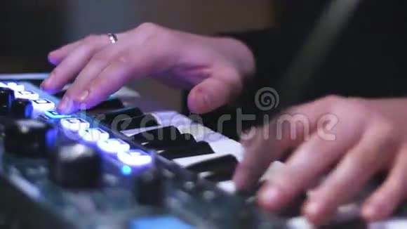 音乐艺术家手在电子键盘上演奏的特写照片和控制桌上的压垫视频的预览图