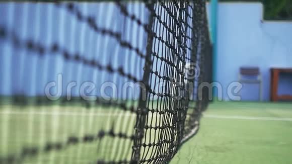 在阳光明媚的日子里网球的缓慢运动击中了落在网球场上的网格1920x1080视频的预览图