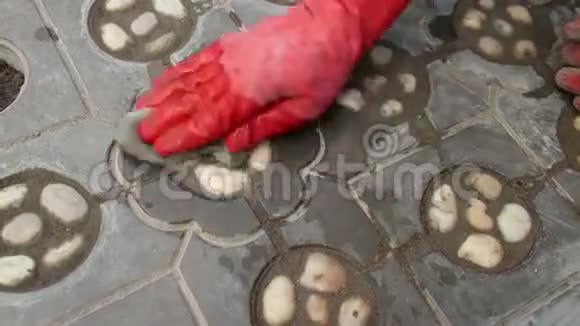 一个工人戴着红手套的手中中的中针在钛中抚平新铺设的石头视频的预览图