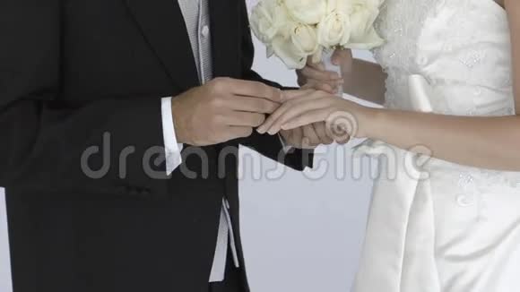 新婚新郎在新娘手指上滑动结婚戒指视频的预览图