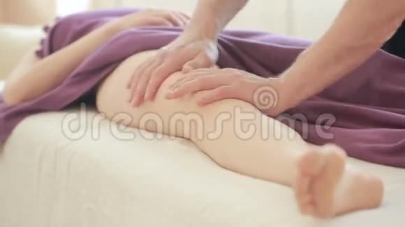 男性按摩治疗师为女性做足底按摩臀部按摩抗纤维素按摩视频的预览图