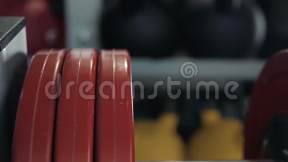 帅哥健美运动员准备在健身房用杠铃做运动把杠铃牌放在健身房里视频的预览图