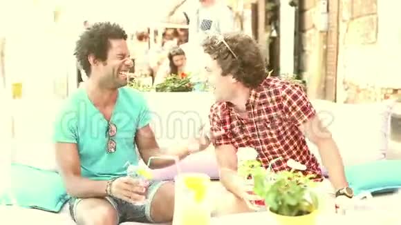 两个男性朋友在夏天的露台咖啡馆喝鸡尾酒视频的预览图
