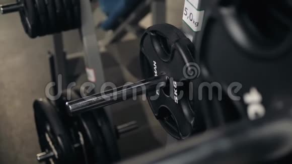 帅哥健美运动员准备在健身房用杠铃做运动把杠铃牌放在健身房里视频的预览图