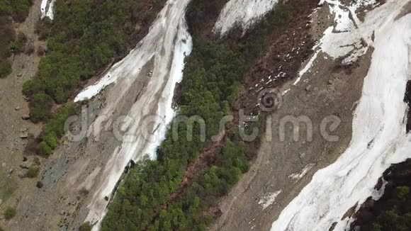冬季雪崩余雪的无人鸟瞰图从山峰上落下视频的预览图