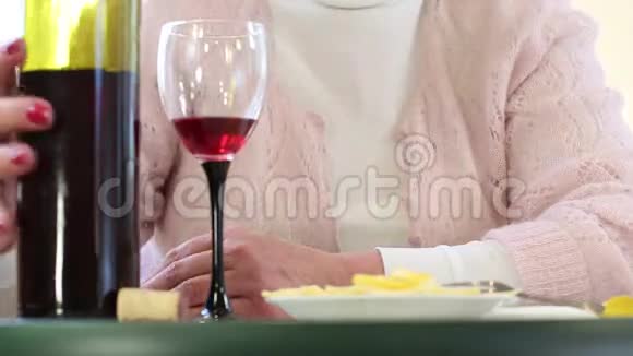 沮丧的高级女人带着一瓶酒女人喝酒视频的预览图