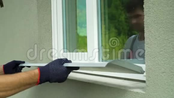 测量外部框架和PVC窗台尺寸的防护手套工人视频的预览图