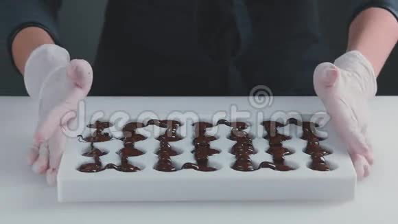 模具中的回火巧克力慢动作糖果视频的预览图
