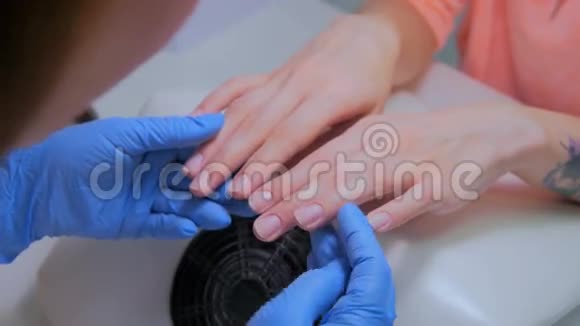 美甲师在美容院握住顾客的手视频的预览图
