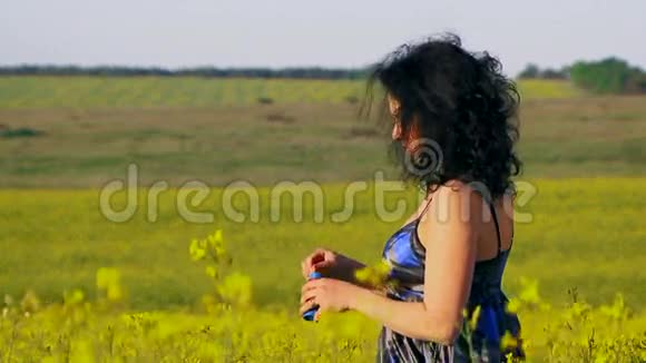 快乐的女人在一片土地上吹泡泡视频的预览图