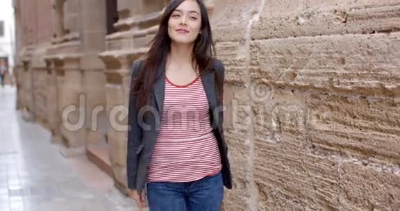 一位年轻女子穿过城镇的小巷视频的预览图