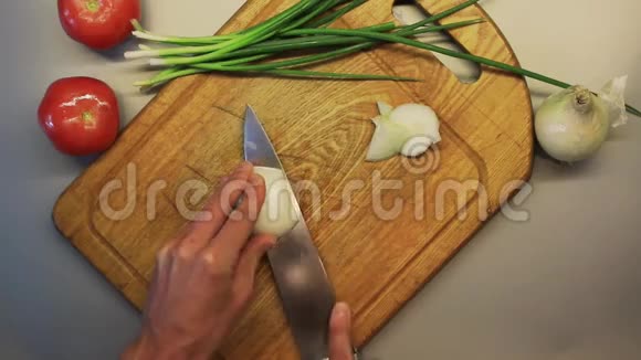 男性手在木制烹饪板上切洋葱视频的预览图
