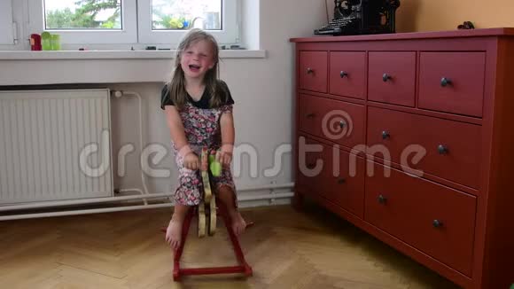 可爱的小女孩在摇摆的马上摇摆小女孩穿花裙子儿童概念视频的预览图
