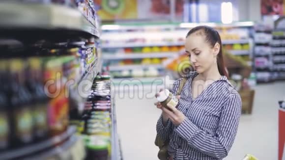 女孩在杂货店看产品视频的预览图