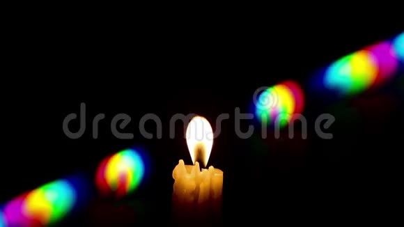 在风烛火焰中振荡周围有彩虹色的反射视频的预览图