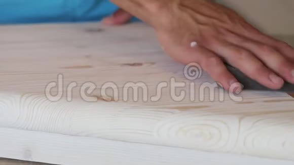 用砂纸将男性手抛光木台阶的特写视频的预览图