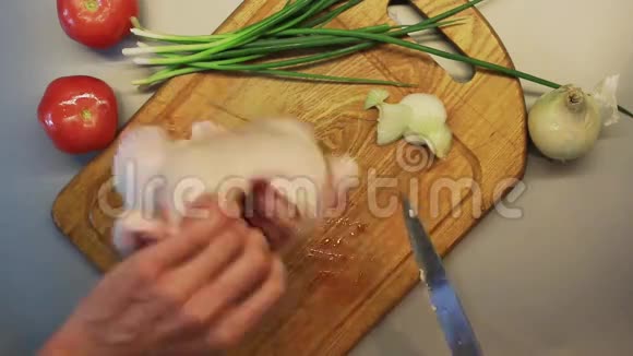 男性手在木制烹饪板上准备整只生鸡视频的预览图