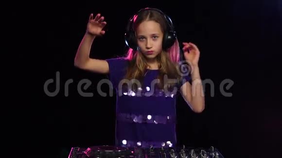 戴着耳机的少女DJ为转盘演奏黑色背景视频的预览图