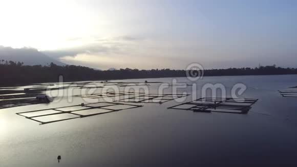 太阳升起在湖中央的竹子结构上无人驾驶飞机空中射击视频的预览图