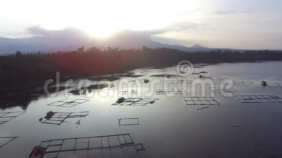 太阳升起在湖中央的竹子结构上无人驾驶飞机空中射击视频的预览图