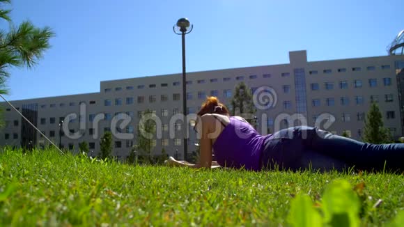 一个戴眼镜的女孩在草地上看书视频的预览图