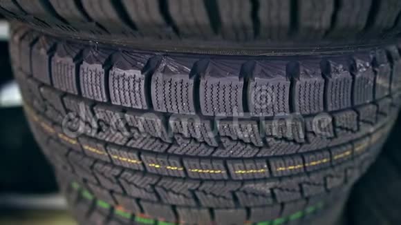 许多新的冬季轮胎在货架上和柱子上店的全景视频的预览图