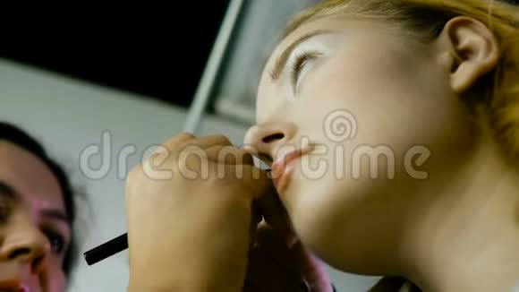 化妆大师描绘了女孩的眼睛化妆特写视频的预览图