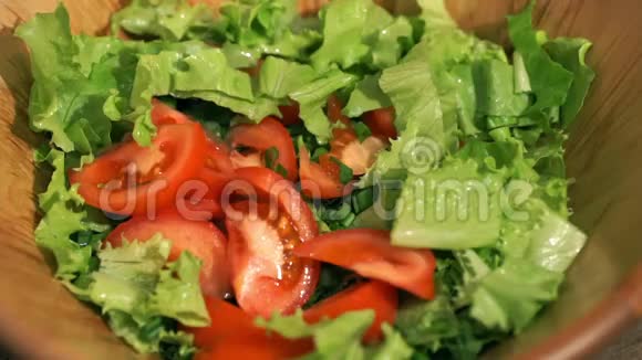 在厨房里搅拌蔬菜沙拉一个木制的肩胛骨视频的预览图