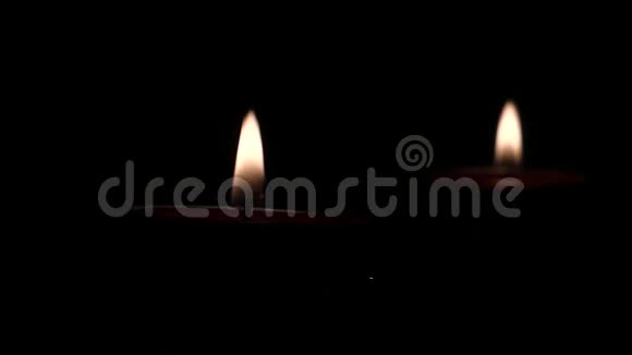 黑暗中两支蜡烛的火教堂里的风视频的预览图