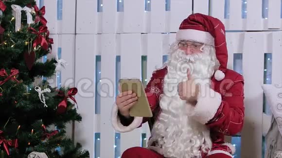 圣诞老人坐在数字平板电脑前视频的预览图