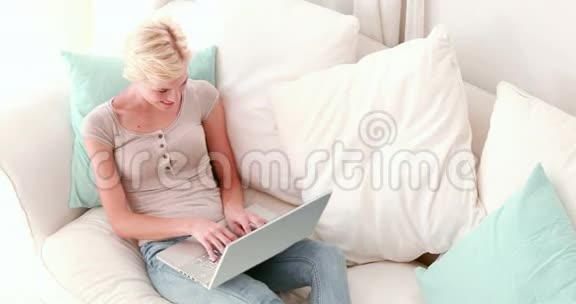 金发美女在她的笔记本电脑上用视频聊天视频的预览图