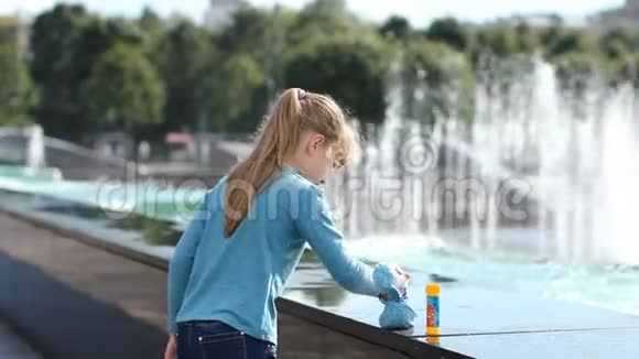 一个女孩在喷泉附近玩水视频的预览图