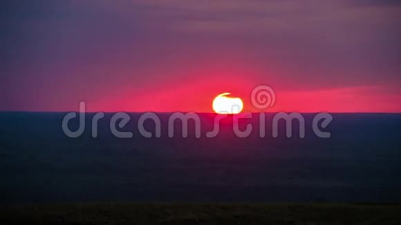 当巨大的太阳落在地平线上时橙色的大日落的时间流逝视频的预览图
