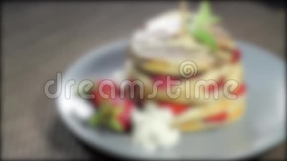 一部分用草莓装饰在盘子上的薄煎饼的录像镜头开始聚焦再次失去焦点视频的预览图