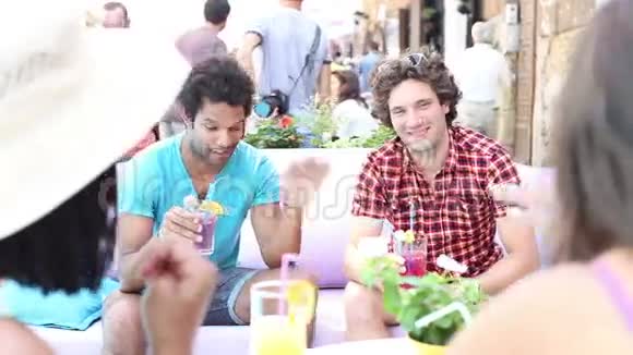 两个男性朋友在夏天的露台咖啡馆喝鸡尾酒视频的预览图
