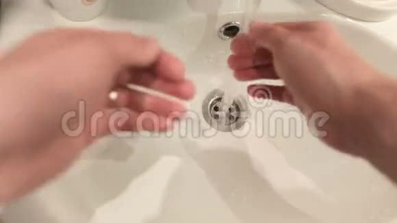 人在白色的水槽里洗手视频的预览图