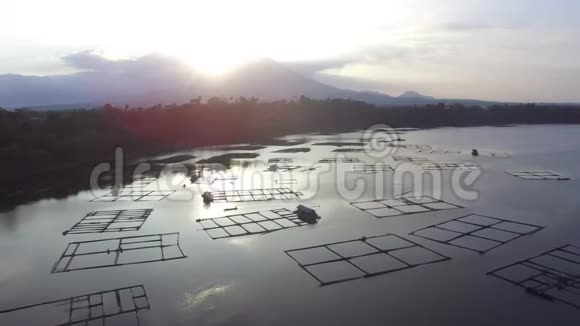 太阳升起在湖中央的竹子结构上无人驾驶飞机空中射击视频的预览图