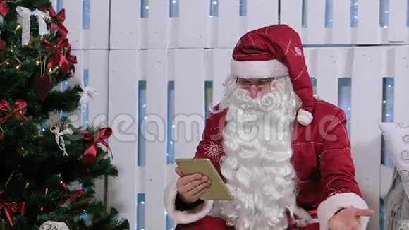 圣诞老人坐在数字平板电脑前视频的预览图