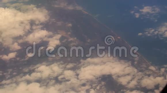 从空运窗口俯瞰云层下的海岸视频的预览图