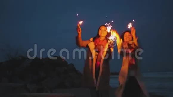 年轻的女人在夜晚的海岸上闪耀视频的预览图