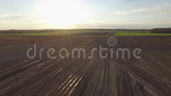 4K日落时分用农业机械在新耕的田野上飞行鸟瞰视频的预览图